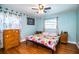 Cozy bedroom with a ceiling fan, hardwood floors, and bright floral bedding at 4739 Tierra Alta Ct, Lakeland, FL 33813