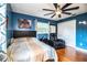 Comfortable bedroom featuring hardwood floors, a ceiling fan, and blue accent wall at 4739 Tierra Alta Ct, Lakeland, FL 33813