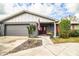 Charming single-story home featuring a gray brick facade, landscaped front yard and an American flag by the front door at 4739 Tierra Alta Ct, Lakeland, FL 33813