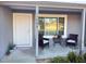 Close-up of the front porch with outdoor seating and decorative plants near the entrance at 15068 Sw 43Rd Ct, Ocala, FL 34473