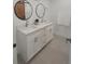 Bathroom featuring a dual sink vanity with white cabinets, white countertops and round mirrors at 1912 Providence Rd, Lakeland, FL 33805