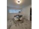 Cozy breakfast nook with a modern glass table, white chairs, large tile flooring, and bright natural light at 1912 Providence Rd, Lakeland, FL 33805