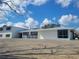 Exterior view of the white home with a metal roof and large front yard at 1912 Providence Rd, Lakeland, FL 33805