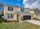 Inviting two-story house showcasing its landscape, two car garage, and neutral color palette at 2448 Brownwood Dr, Mulberry, FL 33860