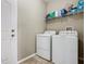 Well-organized laundry room with full-sized washer and dryer, tiled floors, and convenient shelving at 2448 Brownwood Dr, Mulberry, FL 33860