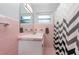 Vintage bathroom featuring pink tile, a sink vanity with a matching mirror and a shower with decorative curtains at 800 22Nd Nw St, Winter Haven, FL 33881