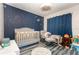 Stylized Bedroom with constellation wall, modern crib, rocking chair, and playful decor for a cozy, imaginative space at 800 22Nd Nw St, Winter Haven, FL 33881