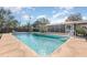 Sparkling in-ground pool with clean, clear water, surrounded by a patio and partial screened enclosure for outdoor enjoyment at 800 22Nd Nw St, Winter Haven, FL 33881