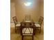 Formal dining room with stylish glass-top table and ornate metal chairs under a modern light fixture at 101 Bent Tree Dr # 12, Daytona Beach, FL 32114