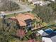 Aerial view of a house with a pool, brown roof, solar panels, and mature trees in a residential area at 12538 Lake View Ln, Clermont, FL 34711