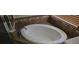 A close up of the white bathtub with stylish brown tile in a well-lit bathroom at 315 Villa Sorrento Cir, Haines City, FL 33844