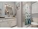 Bright bathroom featuring a tiled shower, white cabinets, and a large, modern mirror at 1176 Balfour Dr, Deltona, FL 32725