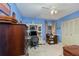 Bedroom with blue walls, white trim, ceiling fan, and a built-in desk and shelving at 1176 Balfour Dr, Deltona, FL 32725