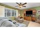 Cozy living room with a ceiling fan, tile flooring, comfortable seating, and a large window for natural light at 1176 Balfour Dr, Deltona, FL 32725