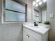 Updated bathroom featuring a modern vanity with stone counters, white cabinets and updated fixtures at 1625 Avenue D Ne, Winter Haven, FL 33881