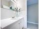 Clean bathroom featuring white tile, modern fixtures, and decorative plant at 1625 Avenue D Ne, Winter Haven, FL 33881