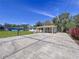 Expansive concrete driveway leading to a charming white home with covered parking at 1625 Avenue D Ne, Winter Haven, FL 33881