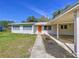 Charming home with a covered carport, a bright orange door, and meticulously maintained landscaping at 1625 Avenue D Ne, Winter Haven, FL 33881