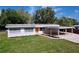 Beautifully maintained home featuring a carport, an orange front door, and lush landscaping at 1625 Avenue D Ne, Winter Haven, FL 33881