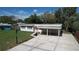 Inviting single-story home featuring a covered carport, well-maintained lawn, and a vibrant orange door at 1625 Avenue D Ne, Winter Haven, FL 33881