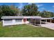 Charming home featuring a bright orange door, carport, and well-manicured lawn at 1625 Avenue D Ne, Winter Haven, FL 33881