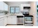 Well-lit kitchen with white cabinets, stainless steel appliances, and elegant tiled backsplash at 1625 Avenue D Ne, Winter Haven, FL 33881