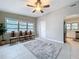 Sunlit living room features neutral walls, ceramic tile, ceiling fan, and connection to the kitchen area at 1625 Avenue D Ne, Winter Haven, FL 33881