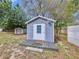 A charming shed with a white door and a small porch provides extra storage at 1625 Avenue D Ne, Winter Haven, FL 33881