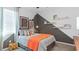 Comfortable bedroom with modern decor, gray walls and a vibrant orange blanket at 2023 Rider Rain Ln, Apopka, FL 32703