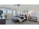 Bright main bedroom featuring accent wall, plush carpet, upholstered headboard, and natural light at 2023 Rider Rain Ln, Apopka, FL 32703