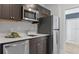 Modern kitchen featuring stainless steel appliances, dark cabinets, and white countertops at 267 Puma Loop, Groveland, FL 34736