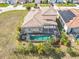 Aerial view of a private home with a screened in pool and spa, lush backyard, and tile roof in a neighborhood at 374 Villa Sorrento Cir, Haines City, FL 33844