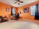 Bright bedroom featuring a ceiling fan, carpeted floor, and desk with a computer setup, bathed in natural light from two windows at 374 Villa Sorrento Cir, Haines City, FL 33844