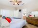 Bedroom with closet, ceiling fan, and dresser, leads to bright bathroom with wood cabinets at 374 Villa Sorrento Cir, Haines City, FL 33844