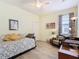 Bright guest bedroom featuring a day bed, ceiling fan, and an accent chair with patterned curtains at 374 Villa Sorrento Cir, Haines City, FL 33844