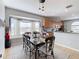 Elegant dining area with a modern light fixture, large window, and seamless flow to kitchen at 374 Villa Sorrento Cir, Haines City, FL 33844