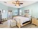 Serene main bedroom boasts a four-poster bed, wood-look tile floors, and outdoor access at 374 Villa Sorrento Cir, Haines City, FL 33844