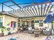 Outdoor seating and dining area inside a screened enclosure with pool access and an adjustable awning at 374 Villa Sorrento Cir, Haines City, FL 33844