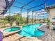 Sparkling pool and spa surrounded by a screened enclosure, brick pavers and lush landscaping at 374 Villa Sorrento Cir, Haines City, FL 33844