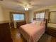 Cozy bedroom features wood floors, ceiling fan, and pink quilted bedspread at 753 Avenue O Se, Winter Haven, FL 33880