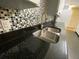 Close-up of the kitchen sink, mosaic backsplash and dark countertops at 753 Avenue O Se, Winter Haven, FL 33880