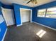 Blue bedroom featuring carpet floors, closet, and a window for natural light at 100 High St, Winter Haven, FL 33880