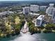 Aerial view of lakefront community featuring high-rise condos, lush trees, and a scenic pier at 101 S Eola Dr # 813, Orlando, FL 32801