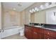 Bathroom featuring double sinks, wood cabinets, and a shower-tub combo at 101 S Eola Dr # 813, Orlando, FL 32801