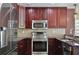 Close-up of kitchen featuring stainless steel appliances, dark cabinets, and granite counters at 101 S Eola Dr # 813, Orlando, FL 32801