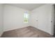 Bright bedroom features neutral carpet, a window with view, and a door to the hall at 409 Ashbury Way, Poinciana, FL 34759