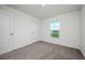 Bedroom features neutral carpet, a window with a view, and two doors at 409 Ashbury Way, Poinciana, FL 34759