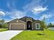 Charming single-story home featuring a two-car garage and well-manicured lawn at 409 Ashbury Way, Poinciana, FL 34759