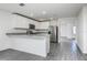 Bright kitchen featuring an island with a breakfast bar, stainless steel appliances and gray wood-look flooring at 409 Ashbury Way, Poinciana, FL 34759