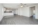 Bright and airy living room with an open-concept design, showcasing gray wood-look flooring and white walls at 409 Ashbury Way, Poinciana, FL 34759